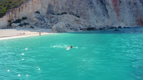 Woman-swimming-in-sea-near-Fteri-beach-in-Kefalonia-Island,-Greece