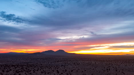 Gleitender-Hyperlapse-Aus-Der-Luft-über-Der-Mojave-Wüste-Mit-Schroffen-Bergen-In-Der-Ferne-Während-Eines-Farbenfrohen-Sonnenaufgangs