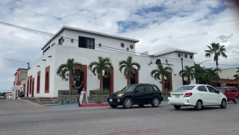 Red-door-frames-and-traffic-in-Todos-Santos,-Mexico