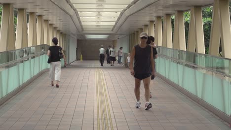 Slow-motion-of-daily-life-in-asiatic-metropolis,-people-walking-on-a-bridge
