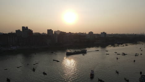 Buriganga-river-port-beside-city-in-sunrise-with-boats---aerial-establishing-drone-flight-shot