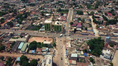 Cinematic-Rising-Aerial-View-of-African-City-traffic,-showing-Twin-Towers-building,-Lomé,-West-Africa
