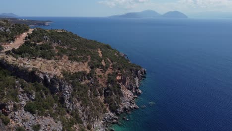 Luftaufnahme:-Hügelinsel-Mit-Blauem-Meer-In-Agiofili,-Lefkada,-Griechenland---Drohne-Fliegt-Nach-Unten-Geneigt