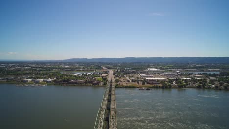 Aerial-over-the-Columbia-River-Interstate-Bridge-pulling-away-from-Portland,-Oregon