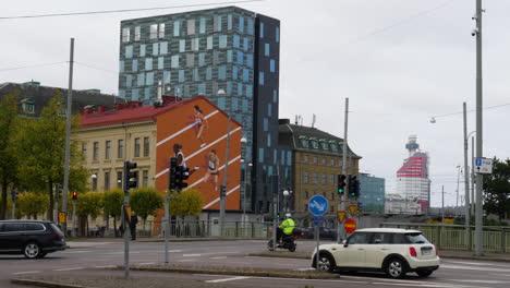Slow-motion-shot-of-traffic-scene-on-road-and-famous-Lipstick-landmark-Building-in-of-Gothenburg,Sweden