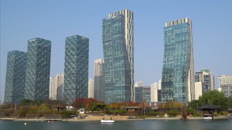 Futuristic-Incheon-Songdo-Central-Park-appartment-complex-buildings-view-against-clear-sky-from-lake-waterfront-in-Autumn---static-landscape