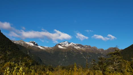 Time-lapse-shot-of-flying-clouds-over-mountain-range-during-sunny-day-with-blue-sky---Milford-Track-in-Fiordland-National-park