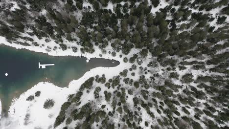 Aerial-ascending-during-winter-clockwise-above-Caumalake-and-Forest,-Switzerland