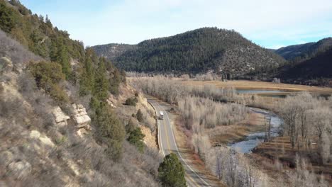 Blick-Auf-Die-Berge-In-Colorado-Mit-Sattelschlepper,-Der-Die-Straße-Hinunterfährt