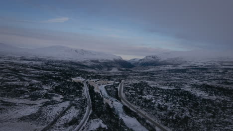 Vista-Aérea-De-La-Ruta-Europea-E6-A-Lo-Largo-Del-Río-Drivdalen-En-El-Parque-Nacional-Dovrefjell–sunndalsfjella-En-Noruega-En-Invierno