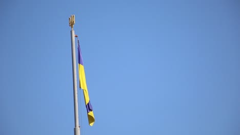 Bandera-Nacional-De-Ucrania-Ondeando-En-El-Viento-En-La-Parte-Superior-De-Un-Asta-De-Bandera-Sobre-Un-Fondo-De-Cielo-Azul-Con-Espacio-De-Copia