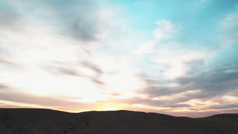 Timelapse-of-a-beautiful-sunset,-where-the-sky-paints-itself-in-multiple-colors-over-the-desert-sand-dunes-of-Israel