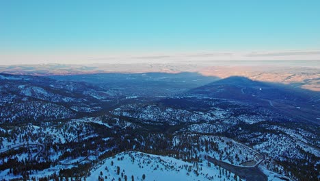 Aerial-view-over-mountains-with-snow-forest-landscape-in-California,-Lake-Tahoe-area