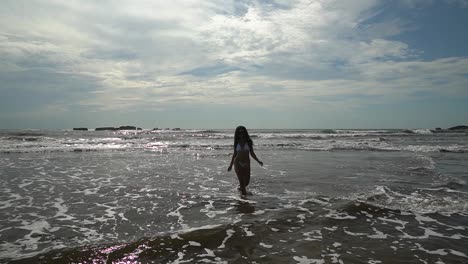 Slow-motion-shot-of-woman-walking-and-having-fun-in-the-sea-on-holiday