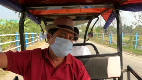 Hombre-Indio-Que-Viaja-En-Un-Auto-rickshaw-Tuk-tuk-Eléctrico-En-La-India-Rural-Durante-La-Pandemia-De-Covid-19