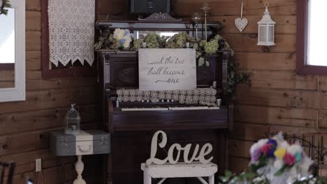 Rustikales-Dekor-Für-Den-Hochzeitsempfang-Mit-Einem-Liebeszeichen,-Einem-Klavier,-Verschiedenen-Blumen-Und-Kerzendekorationen