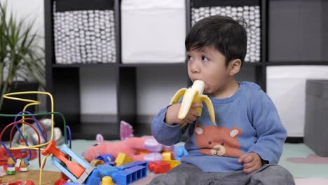 Niño-Mexicano-De-Dos-Años-Comiendo-Un-Plátano,-Comida-Saludable,-Día-Del-Niño