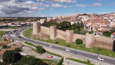 Avila,-Castile-and-León,-Spain---Aerial-view-of-the-City-Walls,-Cathedral-and-Driving-Cars
