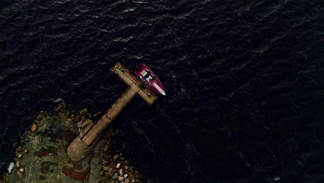 An-aerial-vertical-shot-of-a-lonely-vessel-moored-to-a-pier