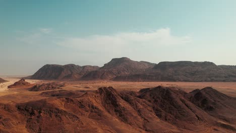 Aerial-reveal-of-a-huge-colorful-desert-mountain-line-and-horizon