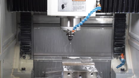 Automatic-CNC-machine-starting-drilling,-cooled-by-a-cutting-fluid