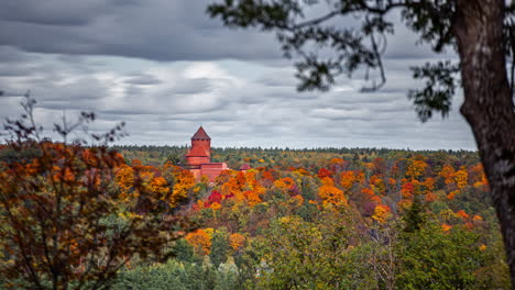 Turaida-Castle-seen-above-colorful-autumn-treetops-on-cloudy-day