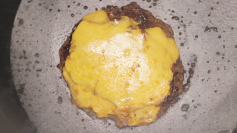 Creamy-Cheese-Melted-On-A-Beef-Patty-While-Cooking