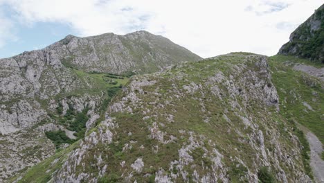 Wunderschöne-Hohe,-Steile-Graue-Bergwände,-Die-Teilweise-Mit-Grüner-Vegetation-In-Der-Ausgedehnten-Landschaft-Der-Valles-Pasiegos-In-Spanien-Bewachsen-Sind