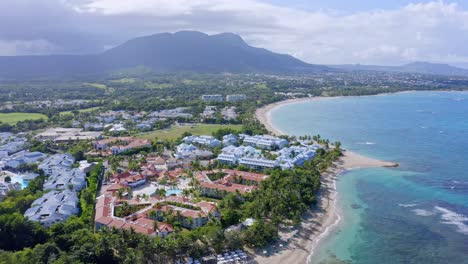 Aerial-View-of-Coastline-of-Playa-Dorada-Beach-Resort-Exclusive-Complex-with-Mountain-Landscape-in-Background