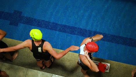 Männliche-Schwimmer-Wärmen-Sich-Vor-Dem-Schwimmwettbewerb-Außerhalb-Des-Beckens-Auf
