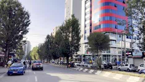 Coches-En-La-Carretera-En-Addis-Abeba,-Etiopía,-Escena-Callejera-Moderna-Con-Rascacielos-En-Etiopía