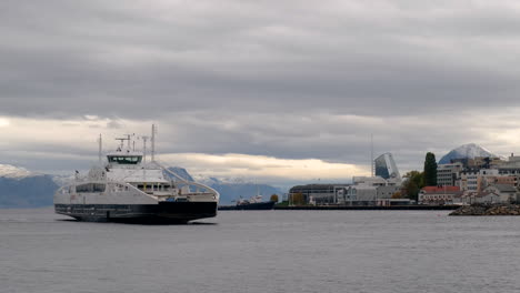 Ferry-Arriving-Molde-Harbour-On-A-Cloudy-Day-With-Mountains-View-In-The-Background,-Norway