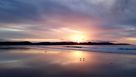 Malerischer-Sonnenuntergang-Mit-Meereswellen,-Die-Am-Ufer-Der-Spirits-Bay,-Neuseeland,-Plätschern-–-Drohnenaufnahme