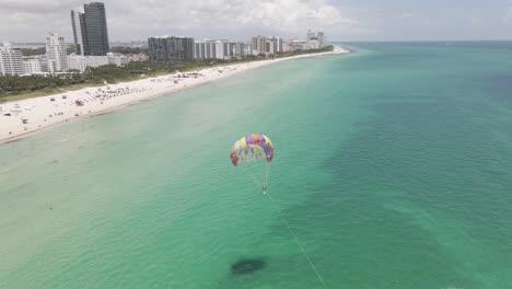 Colorful-parasail-advertises-for-tourists-in-aerial-off-Miami-Beach