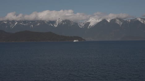 BC-ferry-boat-navigating-on-sea-water-with-mountains-in-background,-British-Columbia