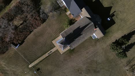 Top-down-aerial-view-in-4k-of-a-person-walking-along-narrow-paved-path-and-going-to-church