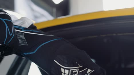 Racing-driver-puts-on-his-black-and-blue-gloves-in-slow-motion