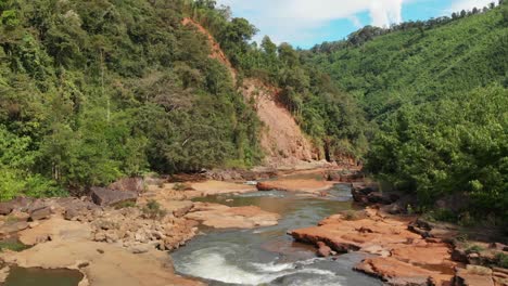 Natur-In-Laos,-Fluss-Und-Orangefarbene-Steine-Und-Land-Rundherum,-Drohnenansicht-Aus-Der-Luft