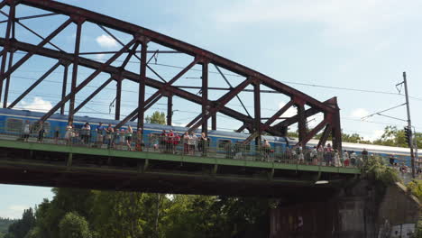 Aufblicken-Zu-Einer-Menschenmenge-Von-Zuschauern-Auf-Einer-Eisenbahnbrücke,-Náplavka-Ufer,-Ansehen-Eines-Freeski-Events,-Prag