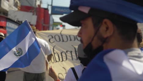 Salvadorianer-Gehen-Mit-Der-Nationalflagge-Während-Eines-Friedlichen-Protests-In-Den-Straßen-Der-Stadt-Gegen-Den-Derzeitigen-Präsidenten-Nayib-Bukele-–-Zeitlupe