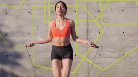Millennial-Hispanic-Woman-using-jump-rope-in-urban-park,-Medium-Shot