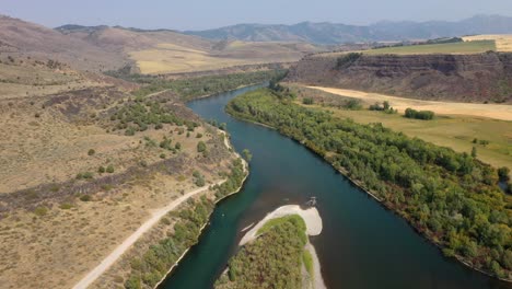 Gewundener-Fluss-In-Idaho-Mit-Berglandschaft-Und-üppigen-Grünen-Bäumen-Im-Sommer
