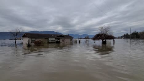 A-devastating-scene-of-a-residential-house-submerged-in-flood-water,-the-horrendous-flooding-has-caused-a-tremendous-amount-of-damage-to-properties-and-homes-in-the-area-in-British-Columbia,-Canada