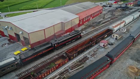 An-Aerial-View-of-an-Antique-Steam-Passenger-Train-Approaching-Station-Thru-Freight-Yard