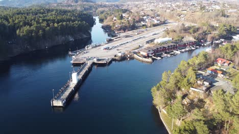 Halhjem-ferry-pier-in-Os-Norway---Aerial-overview-of-quay-with-long-line-of-cars-waiting-for-ferry-to-Sandvikvag-along-road-E39