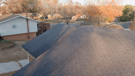 Man-Sitting-On-House-Porch-Flying-Drone-Over-The-Roof,-Durham-Suburb