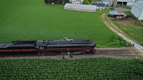 An-Aerial-Parallel-View-of-an-Antique-Steam-Passenger-Train-Blowing-Smoke-Thru-Amish-Farm-Lands