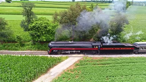 An-Aerial-Parallel-View-of-an-Antique-Steam-Passenger-Train-Traveling-With-Black-Smoke-Thru-Farmlands
