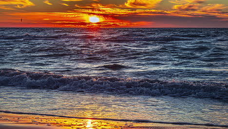 Time-lapse-shot-of-waves-on-Baltic-Sea-with-many-people-walking-at-shore-during-golden-sunset