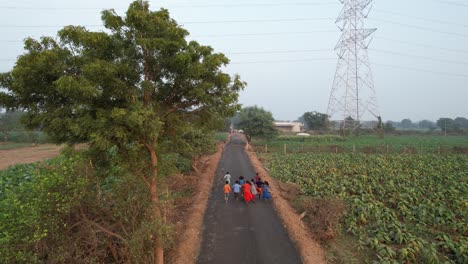 Indian-child-on-bicycle-running-aerial-view,-village-aera-road,-vintage-look,-indian-village-life-aerial-1